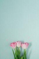 mooi roze voorjaar tulpen Aan een licht munt achtergrond met roze pailletten leggen vlak. een kopiëren van de ruimte. Valentijnsdag dag kaart, verjaardag, verjaardag, maart 8, Pasen foto