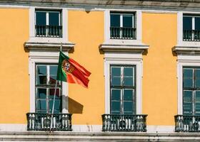 Portugees vlag Aan geel facade reflecterend Aan venster foto