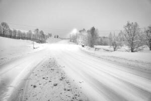 winter landschap in Scandinavië in zwart en wit. besneeuwd weg met sneeuw gedekt bomen foto