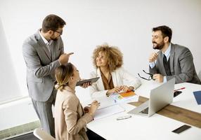 groep jonge zakenmensen werken en communiceren zittend aan het bureau samen foto