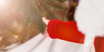 kleine babyhandje raakt kerst- of nieuwjaarsboom foto