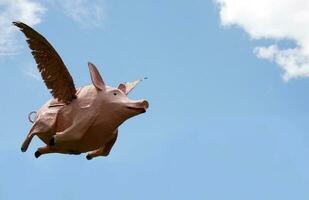 wanneer varkens vlieg humoristisch buitenshuis beeldhouwwerk foto
