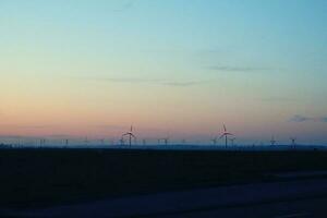 landschap met zonsondergang en wind boerderij windmolens na donker foto