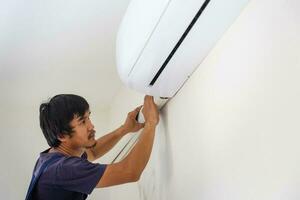 technicus Mens installeren lucht conditioning in een cliënt huis, jong klusjesman vaststelling lucht conditioner eenheid, onderhoud en repareren concepten foto