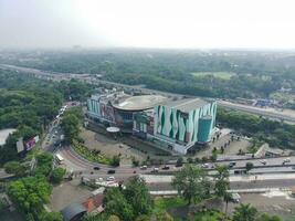 boef, Indonesië - 2022. 4k beeldmateriaal antenne visie van een boodschappen doen winkelcentrum Bij een kruispunt. foto