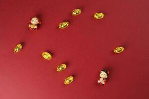 Chinese jongen meisje pop beeldje geld paardenknecht baar goud Aan rood achtergrond kopiëren ruimte foto