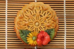 kleurrijk bloem versierd mooncake Chinese midden herfst festival Aan bamboe voedsel mat achtergrond foto