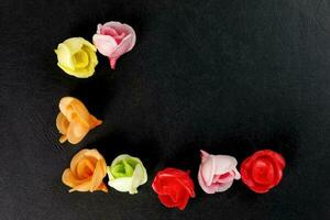 wafel eetbaar papier biscuit roos bloem taart decoratie Aan zwart achtergrond rood groen roze geel foto