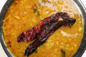 dal linze bakken tadka met droog chili in koper pot Aan wit achtergrond foto