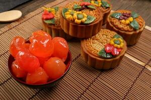 midden herfst feestelijk kleurrijk bloem versierd maan taart maken ingrediënten gezouten ei dooier achtergrond Aan bamboe voedsel mat foto