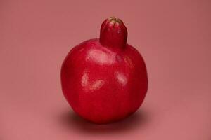 rijp granaatappel Aan de roze achtergrond foto
