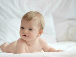 blond schattig baby aan het liegen Aan bed foto