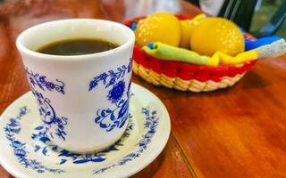 blauw wit kop pot met zwart koffie houten tafel Mexico. foto