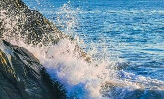 surfer golven turkoois blauw water rotsen kliffen keien puerto escondido. foto