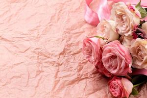 een boeket van mooie rozen op een roze ambachtelijke achtergrond met ruimte voor tekst foto