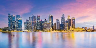 skyline van het financiële district van singapore in marina bay op schemeringtijd foto