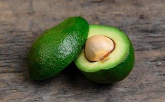verse avocado in tweeën gesneden op een houten bord achtergrond foto