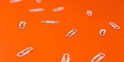 close-up van witte paperclips op een oranje achtergrond foto