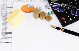 hypotheekleningen concept met geel papier close-up funtain pen en munten en rekenmachine en bril foto