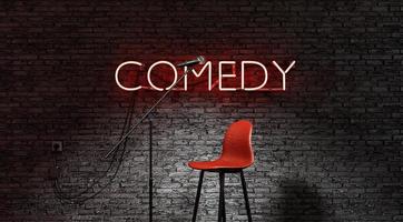 podium verlicht door een schijnwerper en een rode neonlamp met het woord komedie foto
