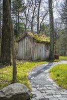 oud houten huis met een met mos bedekt dak