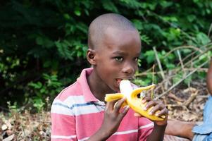 kind eet een banaan op het platteland foto