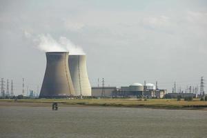 rook die opstijgt uit industriële schoorsteen in energetische fabriek foto