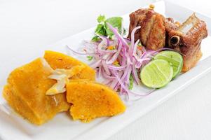 traditionele Peruaanse maaltijd genaamd chicharron de panceta de cerdo geserveerd in een restaurant foto