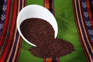 rode quinoa graan rode quinoa graan op een witte plaat op een inca-mantel foto