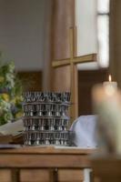 kerkkruis staat op een altaar met een communiebeker en een wazig brandende kaars foto