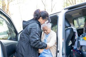 hulp en ondersteuning Aziatische senior of oudere oude dame vrouw patiënt zittend op rolstoel voor te bereiden op haar auto