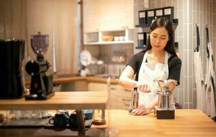 vrouw hand- puree koffie Boon in koffie Slijper Aan houten tafel. foto