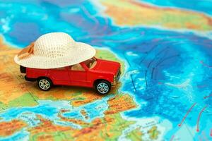 rood speelgoed- auto Aan de fysiek kaart van de wereld Aan de gebied van Afrika in een zomer rietje hoed foto