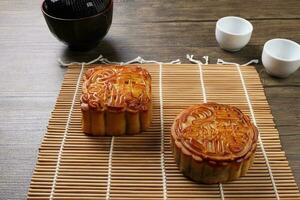 Chinese gebakken versierd mooncake midden herfst festival plein ronde maan taart vulling geschenk wens aanbieden Aan bamboe mat over- houten tafel mini kop foto