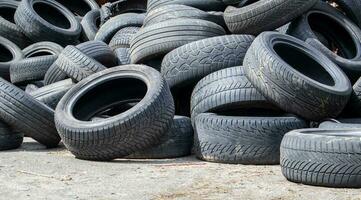 vuilnis van een stapel van zwart oud auto banden. milieu vervuiling. ecologisch problemen. oud auto banden gegooid in een industrieel stortplaats voor recyclen. hergebruik van versleten rubber banden. foto