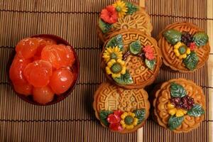 midden herfst feestelijk kleurrijk bloem versierd maan taart maken ingrediënten gezouten ei dooier besnoeiing plak Aan blauw keramisch bord achtergrond Aan bamboe voedsel mat foto