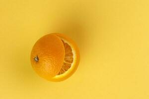 gezond oranje besnoeiing drijvend top plak sap drinken idee concept Aan geel achtergrond foto