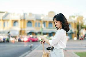 portret mooi Aziatisch vrouw reiziger met camera onderzoeken straat Aan zomer vakantie in Bangkok, Thailand foto