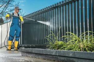 Kaukasisch mannen het wassen zijn woon- oprit poort foto