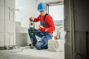 professioneel elektricien met gat zag gedurende werk foto