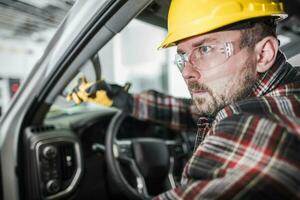 bouw arbeider in geel moeilijk hoed weggaan zijn oppakken vrachtauto foto