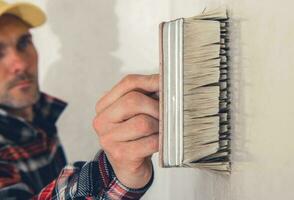 muren priming gebruik makend van groot schilderij borstel foto