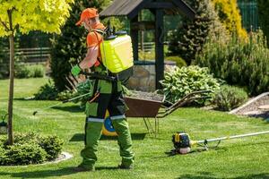 professioneel tuinman het uitvoeren van tuin sproeien foto