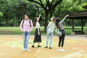 jong Aziatisch Maleis Chinese Mens vrouw buitenshuis park wandelen staan studie praten bespreken punt laptop het dossier boek rugzak foto