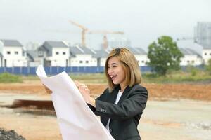 vrouw Chinese Maleis arbeider ingenieur beheer Bij bouw plaats lezing zien plan gelukkig foto