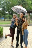 jong Aziatisch Maleis Mens vrouw buitenshuis groen park wandelen praten bespreken mengen onder paraplu foto