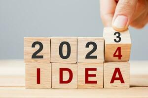 hand- flippen blok 2023 naar 2024 idee tekst Aan tafel. doel, oplossing, strategie, plan, motivatie, opnieuw opstarten, bedrijf en nieuw jaar vakantie concepten foto