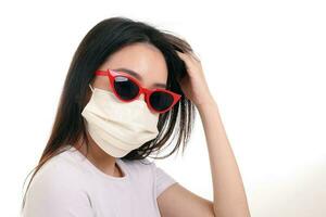 mooi jong zuiden oosten- Aziatisch vrouw vervelend rood kader donker zonnebril drie ply anti virus chirurgisch gezicht masker houding mode stijl wit achtergrond hand- in haar- foto