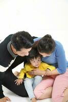 zuiden oosten- Aziatisch Chinese paar man vrouw zoon kind Speel zitten Aan verdieping wit achtergrond liefde foto