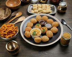 waarheid van Indisch Bengaals straat voedsel thee tijd snacks ui pakoda knapperig pittig linzen moong dal bakken zoet shompapri chaat pani puri fuska Aan rustiek retro tafel bord messing koper potten zilver dienblad foto